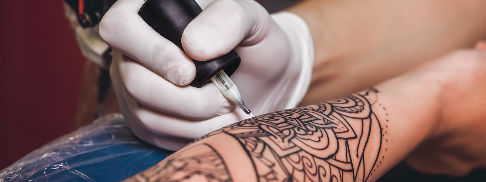 Tattoo artist working on an arm