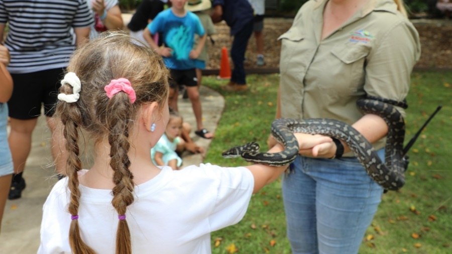 Zoo keeper showing a snake to a child