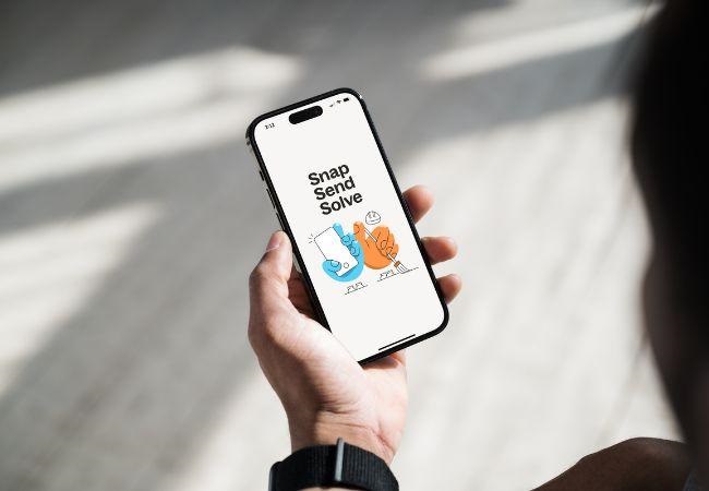 person holding phone with snap send solve app open